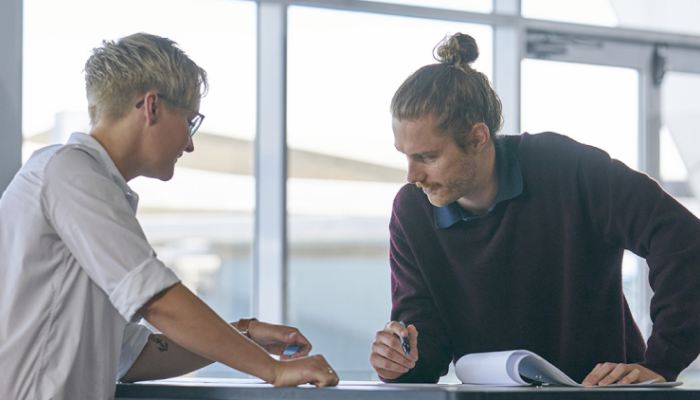 two people looking at paper on table